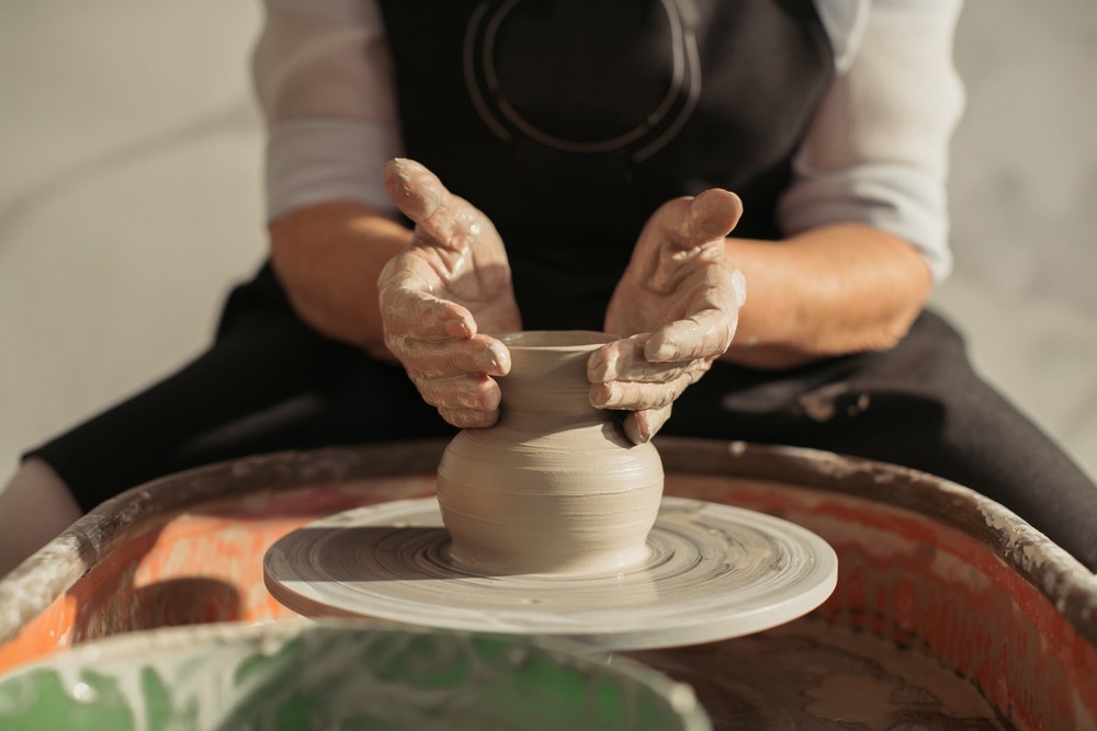 Hands shaping clay on a potter’s wheel