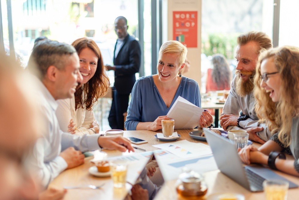 A small group talking and laughing together around a café table